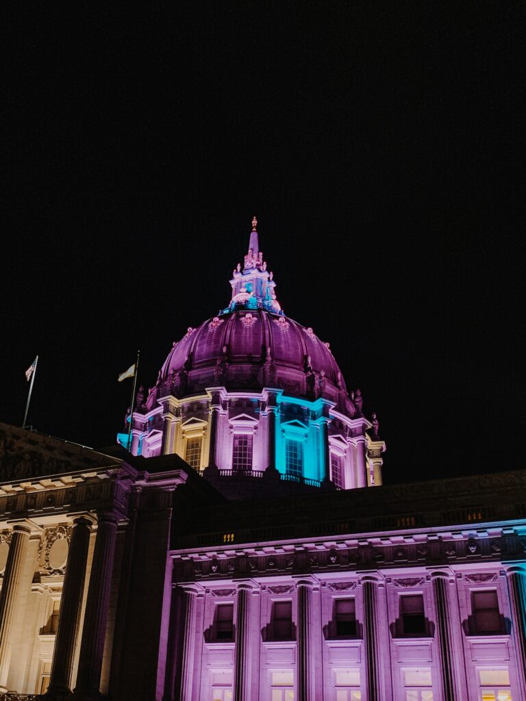 San Francisco city hall lit up with trans flag colors.